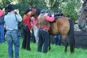 předák umísťuje mochillu s poštou na sedlo